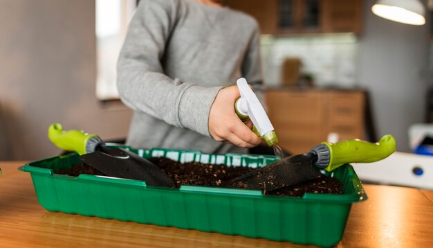 Vorderansicht des kleinen Jungen, der Ernten zu Hause wässert