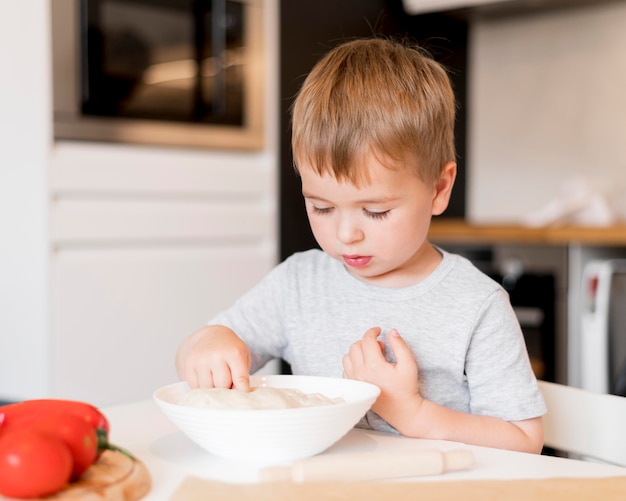 Vorderansicht des kleinen Jungen, der zu Hause kocht