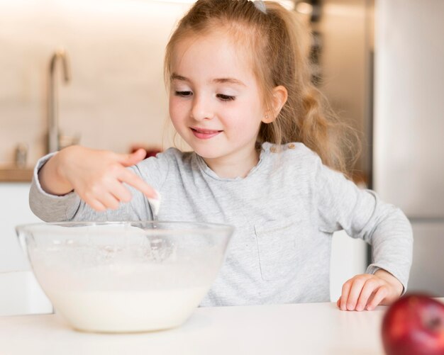 Vorderansicht des kleinen Mädchens, das zu Hause kocht