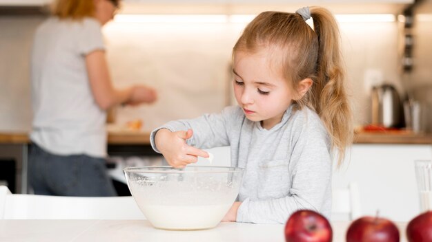 Vorderansicht des kleinen Mädchens, das zu Hause kocht