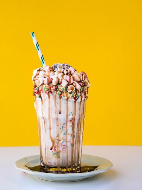 Vorderansicht des köstlichen Milchshakes mit gelbem Hintergrund