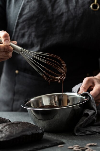 Vorderansicht des Küchenchefs, der Schokoladenkuchen vorbereitet