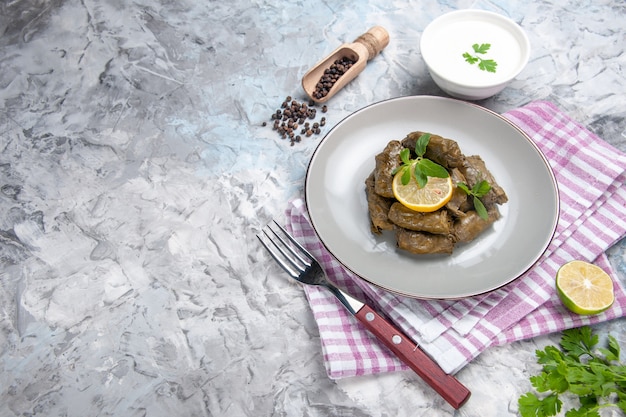 Vorderansicht des leckeren Blattdolmas mit Joghurt auf weißer Oberfläche