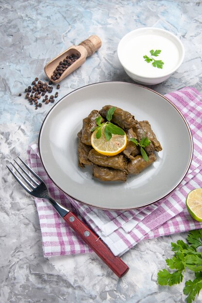 Vorderansicht des leckeren Blattdolmas mit Joghurt auf weißer Oberfläche