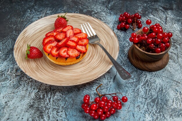 Vorderansicht des leckeren Erdbeerkuchens mit Beeren auf dunkler Oberfläche