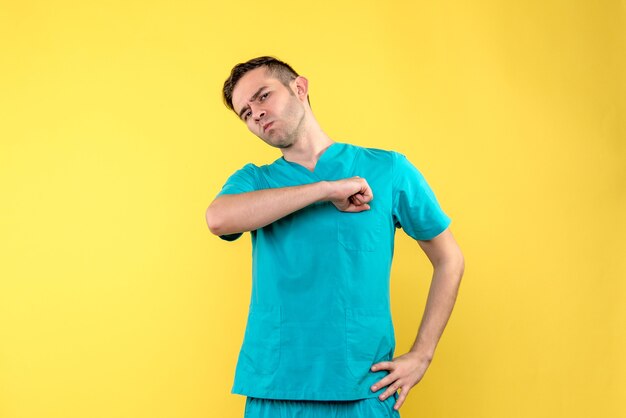 Vorderansicht des männlichen Arztes auf gelber Wand