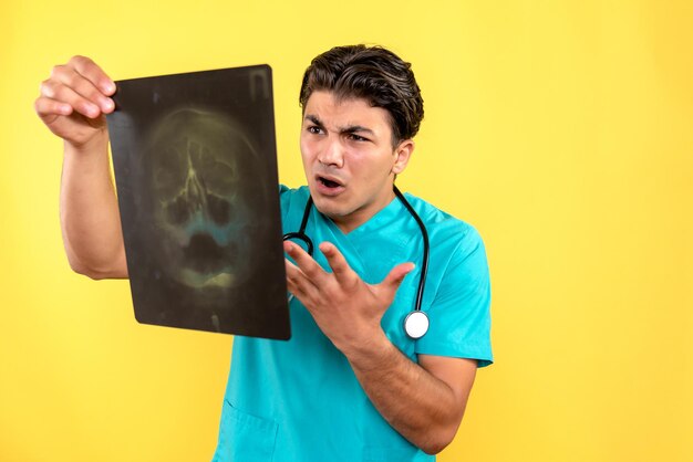 Vorderansicht des männlichen Arztes mit Röntgenaufnahme