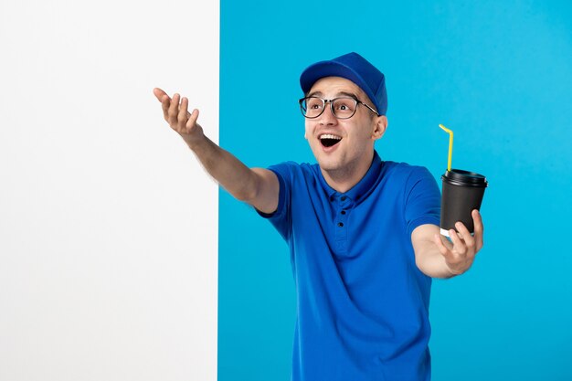 Vorderansicht des männlichen Kuriers in Uniform mit Kaffee auf Blau