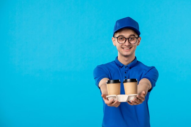 Vorderansicht des männlichen Kuriers mit Kaffee auf dem Blau