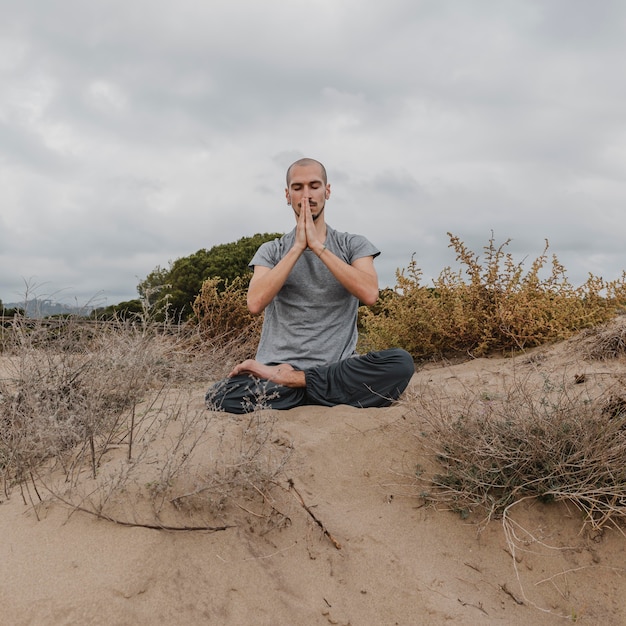 Vorderansicht des Mannes außerhalb des Entspannens beim Yoga