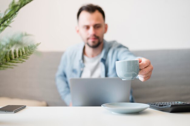 Vorderansicht des Mannes, der an seinem Laptop wotking