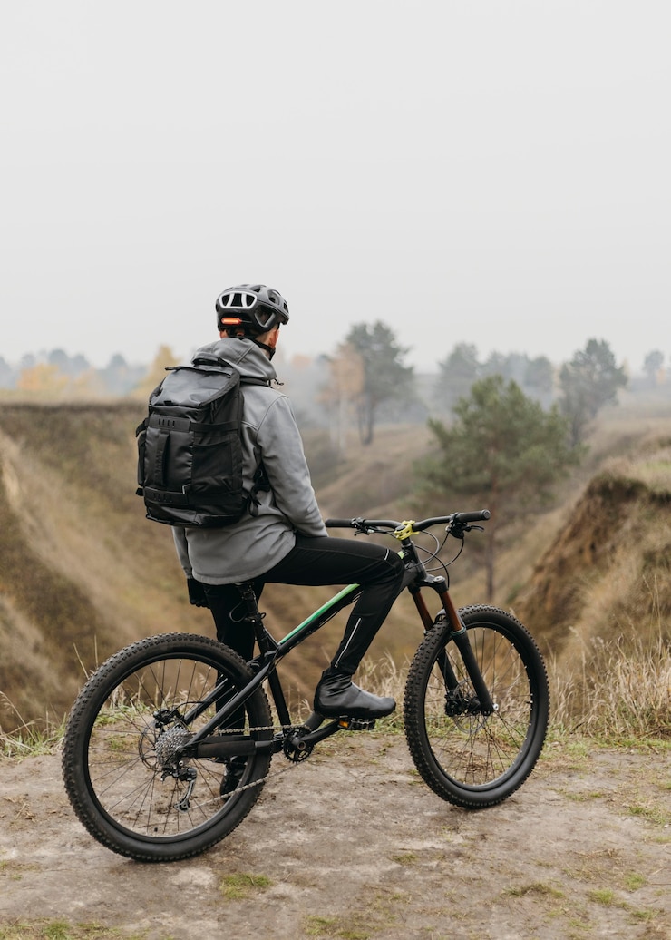 Kostenlose Foto vorderansicht des mannes, der ein fahrrad im berg reitet