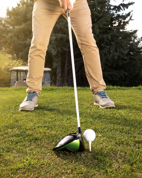 Vorderansicht des Mannes, der Golf auf dem Feld übt