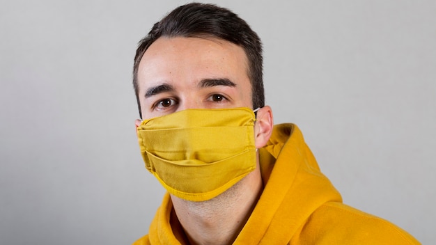 Kostenloses Foto vorderansicht des mannes, der medizinische maske auf gesicht trägt