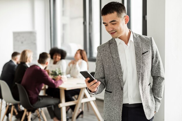 Vorderansicht des Mannes, der sein Telefon betrachtet