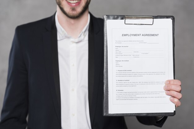 Vorderansicht des Mannes, der Vertrag für neuen Job hält