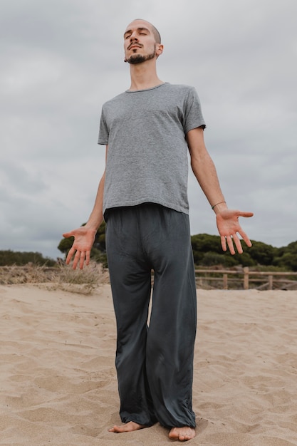 Kostenloses Foto vorderansicht des mannes, der yoga im freien tut