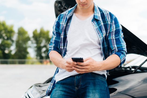 Vorderansicht des Mannes sein Telefon überprüfend