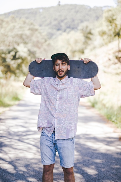 Kostenloses Foto vorderansicht des mannes skateboard halten