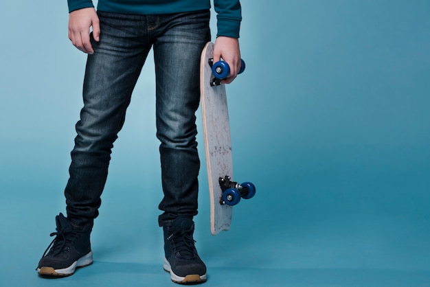 Vorderansicht des modernen Jungen mit Skateboard