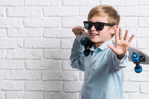 Vorderansicht des modernen Jungen mit Skateboard