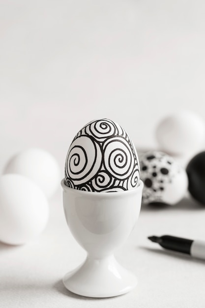 Kostenloses Foto vorderansicht des monochromen eies für ostern im eierbecher mit kopienraum