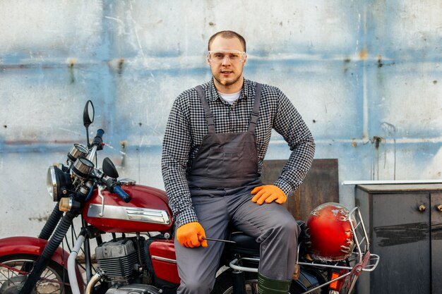 Vorderansicht des Motorradmechanikers mit Handschuhen und Schutzbrille