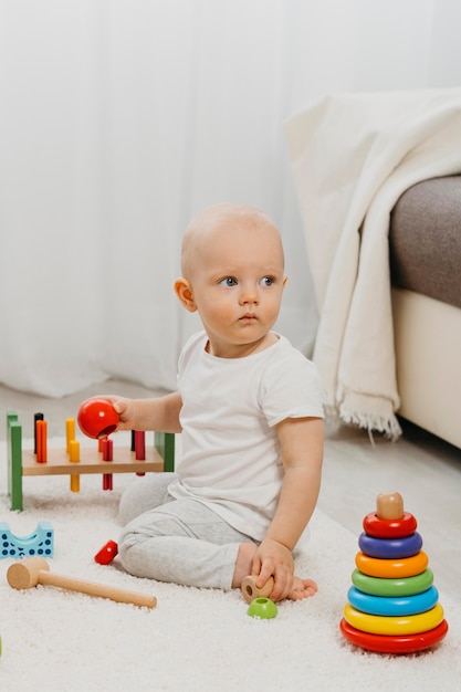 Vorderansicht des niedlichen Babys mit Spielzeug zu Hause