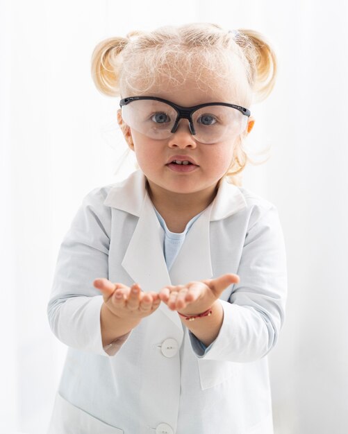 Vorderansicht des niedlichen Kleinkindes mit Laborkittel und Schutzbrille