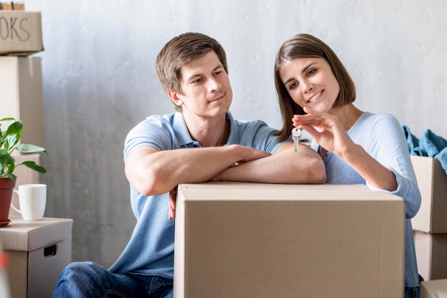 Kostenloses Foto vorderansicht des paares, das schlüssel zum neuen haus hält, während das packen auszieht