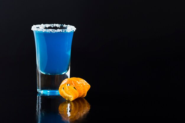 Vorderansicht des Schnapsglases mit blauem Cocktail und Kopienraum