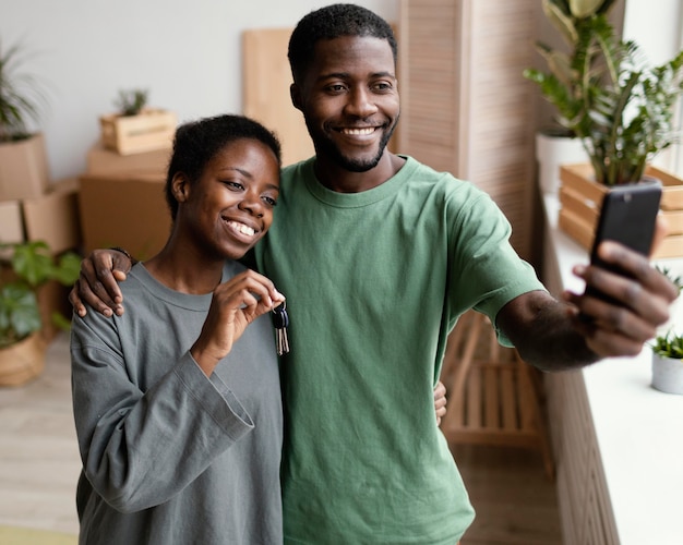 Vorderansicht des Smiley-Paares, das Selfie in ihrem neuen Zuhause nimmt