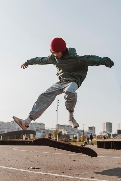 Vorderansicht des Teenagers mit Skateboard außerhalb