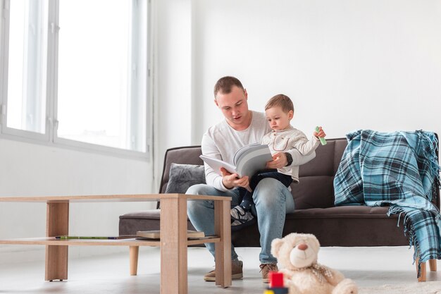 Vorderansicht des Vaters, der Sohn hält und liest