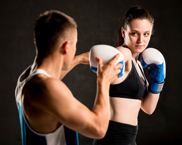 Vorderansicht des weiblichen boxers und des trainers