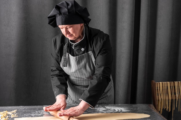 Kostenloses Foto vorderansicht des weiblichen chef rollenden teigs