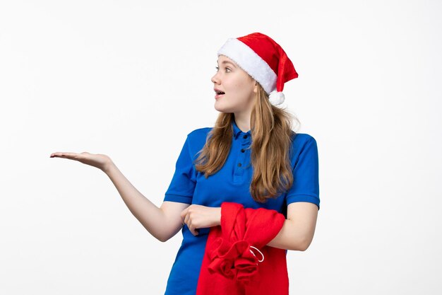 Vorderansicht des weiblichen Kuriers mit Geschenktüte auf weißer Wand