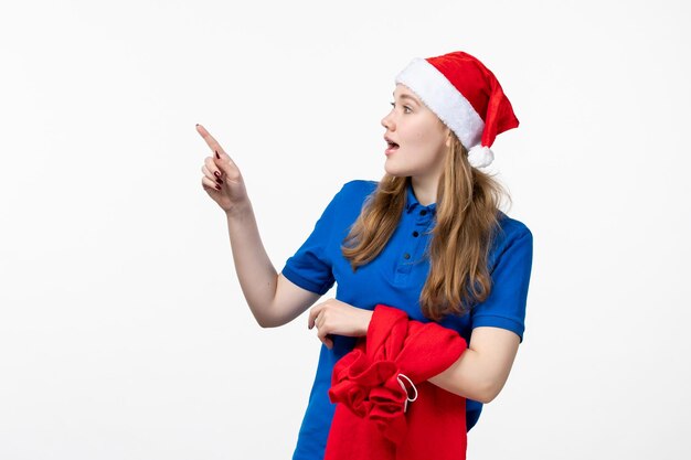 Vorderansicht des weiblichen Kuriers mit Geschenktüte auf weißer Wand