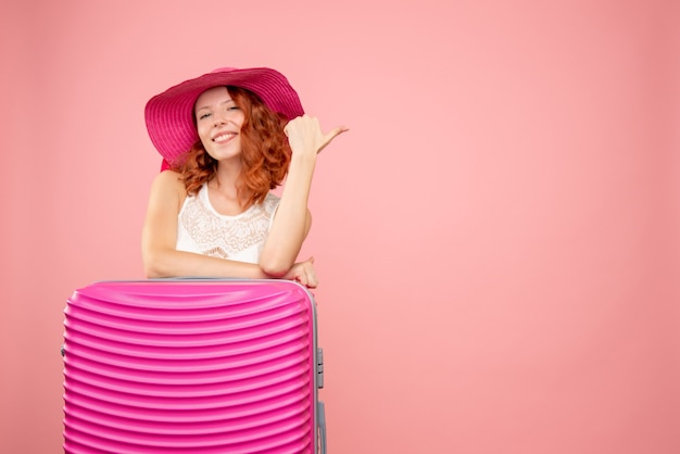 Kostenloses Foto vorderansicht des weiblichen touristen mit rosa tasche an der rosa wand