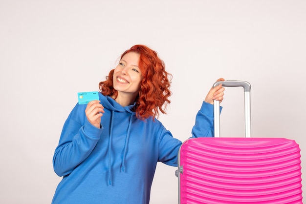 Vorderansicht des weiblichen Touristen mit rosa Tasche auf weißer Wand