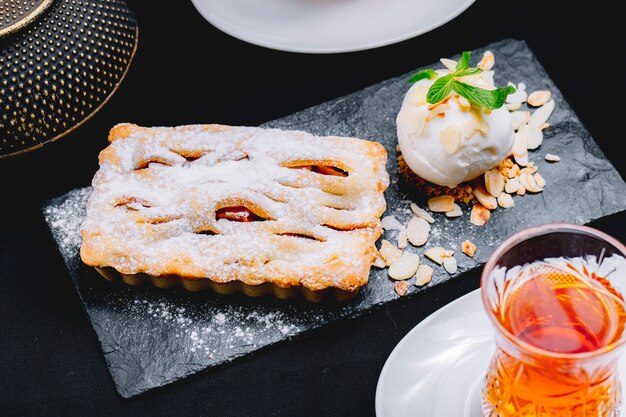 Vorderansicht Dessertkuchen mit Eis und einem Glas Tee