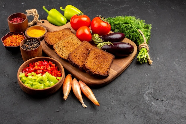 Kostenloses Foto vorderansicht dunkle brotlaibe mit gewürzen tomaten und auberginen auf dunklem hintergrund salat gesundheit reife mahlzeit gemüsediät