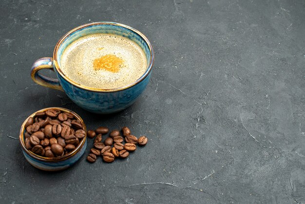 Vorderansicht eine Tasse Kaffeeschale mit Kaffeebohnensamen auf dunklem, isoliertem Hintergrund freier Platz