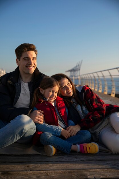 Kostenloses Foto vorderansicht einer familie, die auf einem steg herumhängt