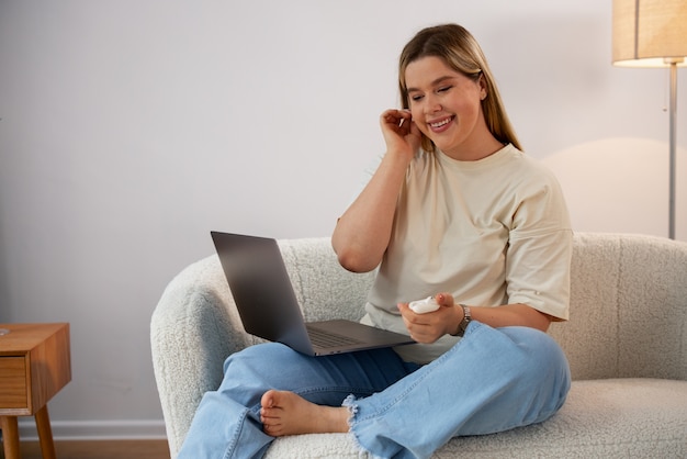 Kostenloses Foto vorderansicht einer frau, die videoanrufe mit einem laptop tätigt