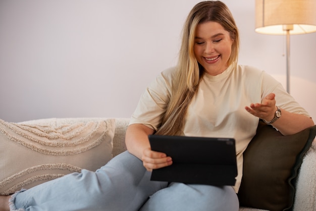 Kostenloses Foto vorderansicht einer frau, die videoanrufe mit einem tablet tätigt