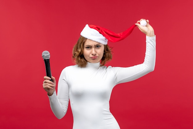 Vorderansicht einer jungen Frau mit Mikrofon auf Rot