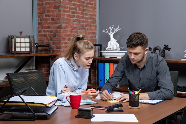 Vorderansicht eines jungen motivierten und fleißigen Büroteams, das sich auf ein Thema in der Büroumgebung konzentriert