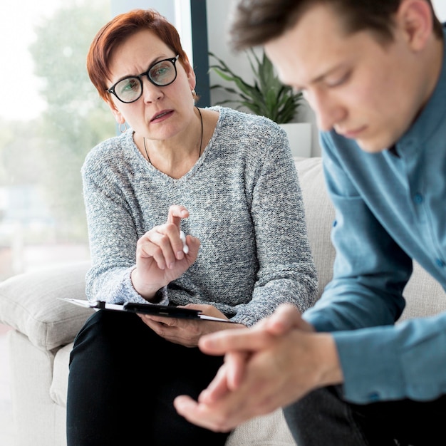 Vorderansicht eines Psychologen, der einen Patienten konsultiert