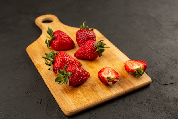 Vorderansicht Erdbeeren rot geschnitten und ganz weich saftig auf dem dunklen Boden